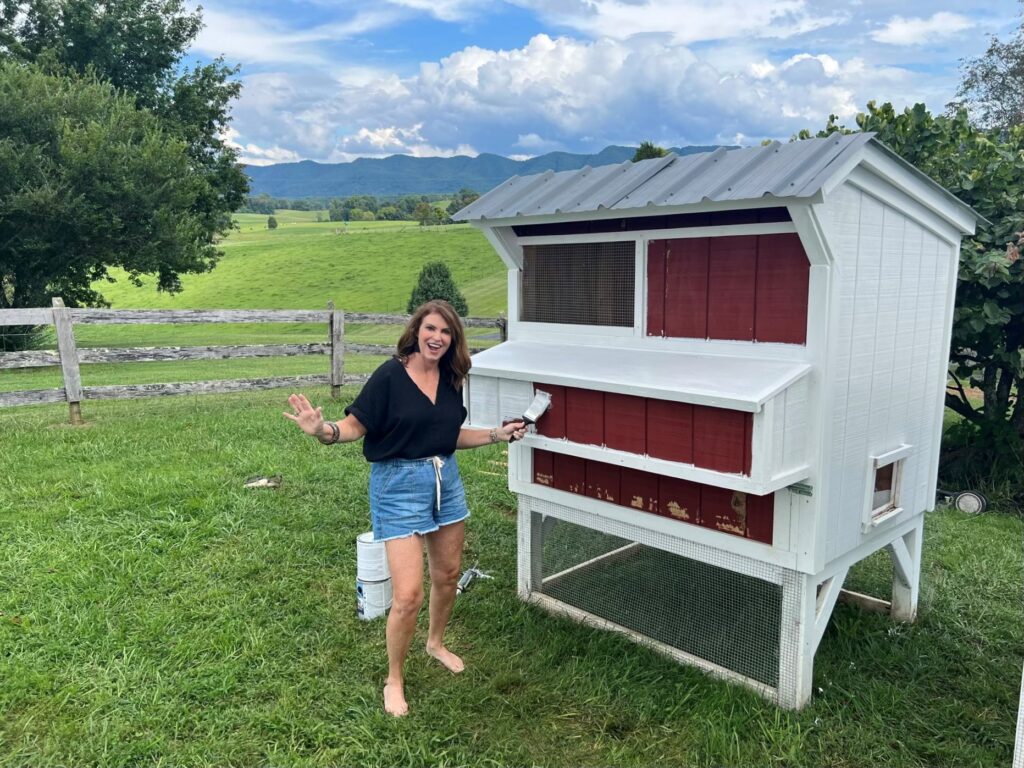 Woman painting chicken coop