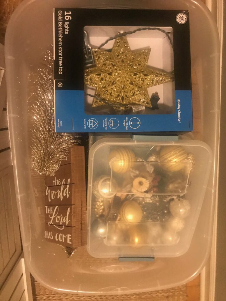 Large clear tote with smaller container of ornaments and tree topper and other matching decorations.