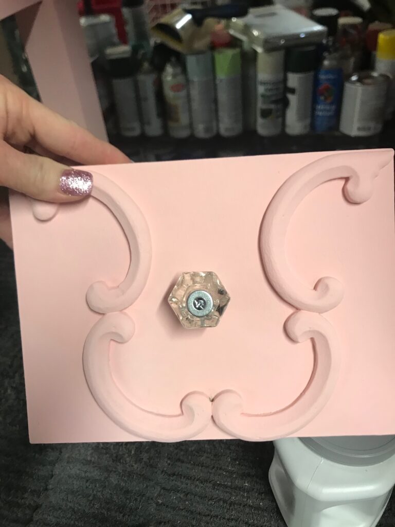 Painted pink vanity drawer with glass hardware.
