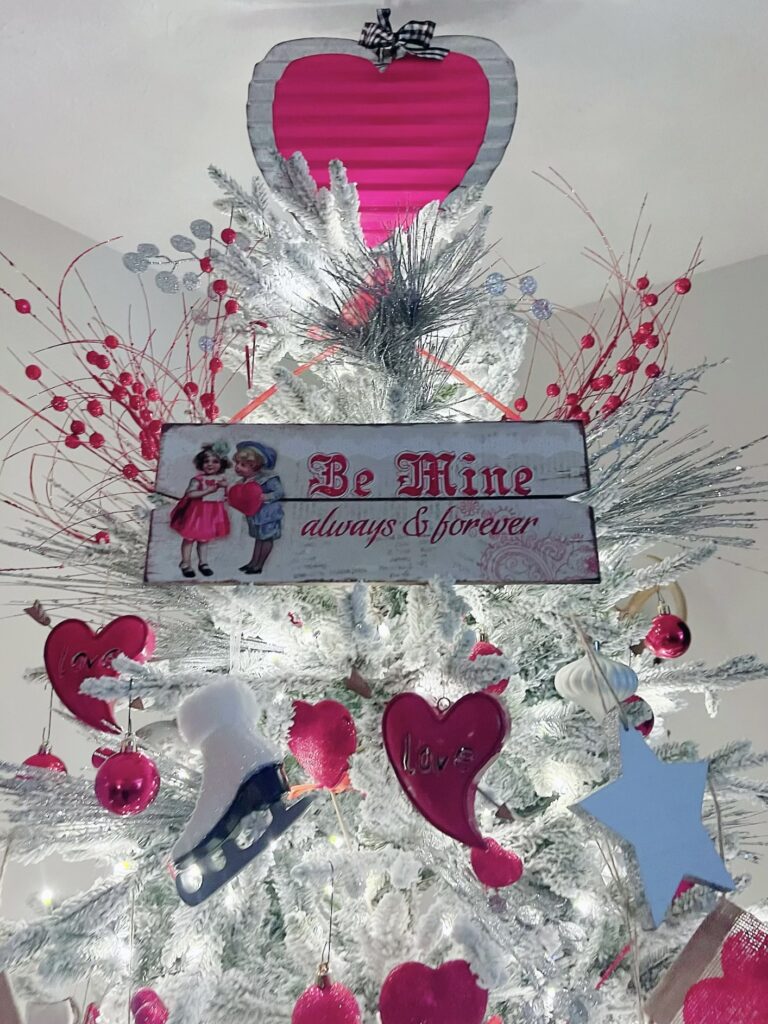 Valentine's Day tree topper with metal heart and a Be Mine sign.